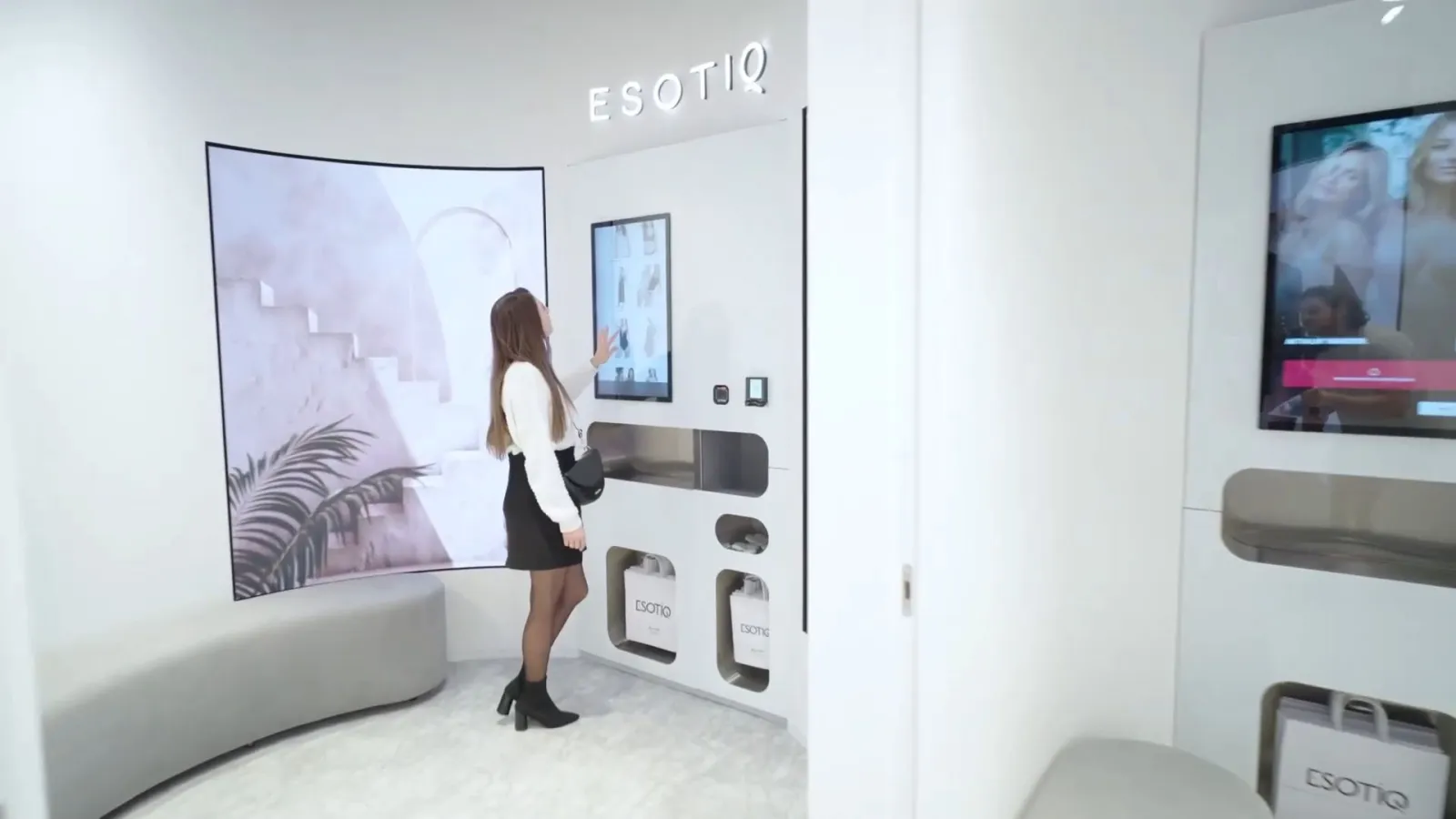 Customer in a closed fitting room with a touchscreen and product hatches